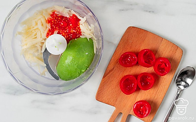 Нарежьте руколу и чеснок, добавьте к авокадо и сыру. Срежьте верхушки с помидоров черри, аккуратно ложкой достаньте мякоть, также положите ее в блендер.