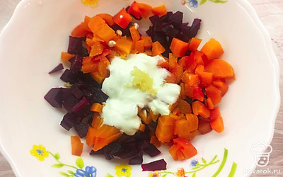 Выложите морковь и свеклу в чашу для салата. Заправьте сметаной, измельчите чеснок и перемешайте. Посолите по вкусу.