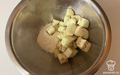 В глубокую миску поместите муку и нарезанный баклажан. 