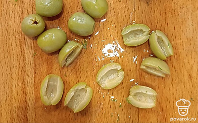 Разрезать оливки на две половинки. 