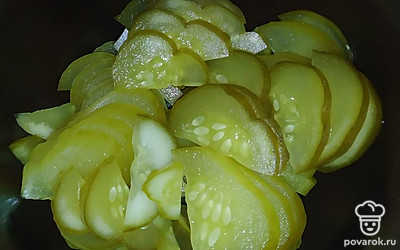 Огурцы нарезаем тонкими полукольцами, складываем в салатницу.