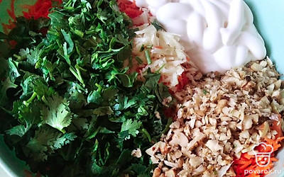 Морковь, орехи, чеснок натереть на тертке. Зелень порезать. Добавить сметану.