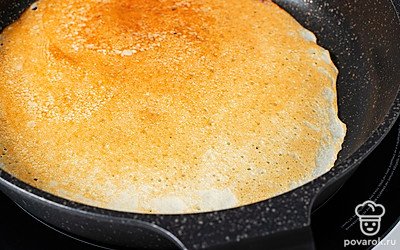 Дождитесь, когда блин подрумянится, переверните и обжарьте до готовности с другой стороны. Приготовьте таким образом все тесто.