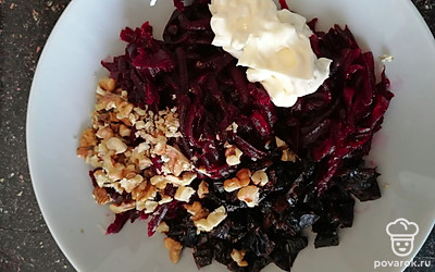 Добавить к свекле мелко нарезанный чернослив, измельчённые грецкие орехи, майонез и соль. 