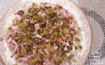 Солёные огурцы нарежьте кубиками, выложите поверх курицы. 