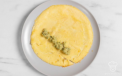 Положите на стол первый омлет. Выложите на него немного ореховой начинки.