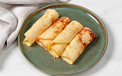 Выложите яичные рулетики на тарелку и подайте на стол в теплом или охлажденном виде.