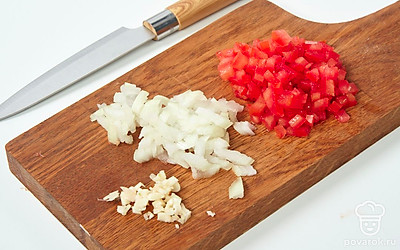 Нарежьте очищенные помидоры мелкими кубиками. То же самое сделайте с луком. Чеснок мелко порубите.