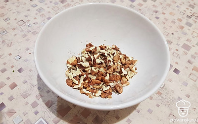 Очистите грецкие орехи от скорлупы и порубите их ножом. 