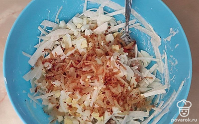 По истечении 20-30 минут маринования нарезанных кусочков редки в подсоленной воде, промойте редьку, нарежьте тонкой соломкой. В отдельную посуду, где панируете замешивать салат, поместите нарезанную редьку, обжаренную куриную грудку, измельченное яйцо, обжаренный лук и майонез. Хорошо все перемешайте.