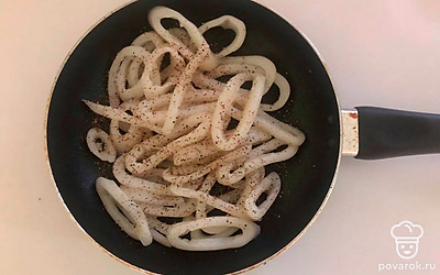 Отварите кальмаров в подсоленной воде 2-3 минуты. Достаньте их и нарежьте кольцами. На оливковом масле обжарьте кольца кальмаров со специями 5 минут.