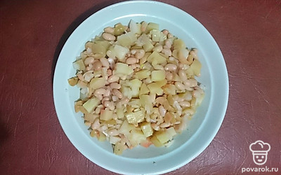 В емкость переложить картофель, лук репчатый, оливки зеленые, консервированную фасоль и добавить оливковое масло. Все перемешать. Оставить на 30 минут, чтобы все ингредиенты пропитались.