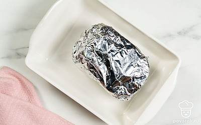 Плотно заверните сало в фольгу. Положите его в форму для запекания и отправьте в духовку на 1,5-2 часа. После этого полностью остудите сало перед подачей. 