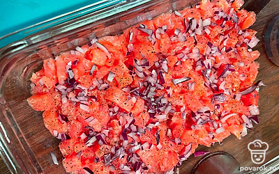 Лосось нарежьте кубиком, выложите в форму, сверху посыпьте луком. По желанию поперчите.