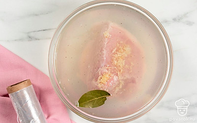 Положите грудинку в контейнер или миску. Залейте остывшим рассолом, а затем закройте его крышкой или пищевой пленкой. Оставьте свинину в рассоле при комнатной температуре в темном месте на один день.