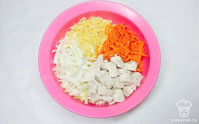 Отварите куриное филе и нарежьте большими кубиками. Сыр натрите на крупной тёрке. Капусту нашинкуйте соломкой.