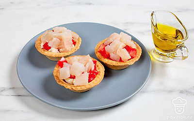 Капните на кубики помидора оливковым маслом, затем положите на них ломтики палтуса.