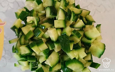 Нарежьте в салатницу огурцы.