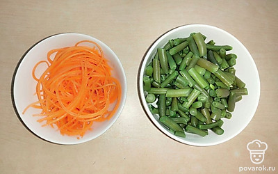 Фасоль отварите в подсоленной воде, нарежьте на кусочки среднего размера. Морковь вымойте, очистите от кожуры, натрите на специальной терке для корейской моркови.