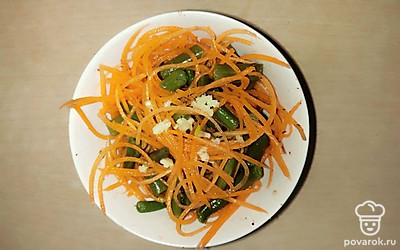 Перемешайте морковь и стручковую фасоль. Добавьте специи: соль, сахар, уксус. Аккуратно перемешайте, чтоб фасоль не потеряла своей формы.