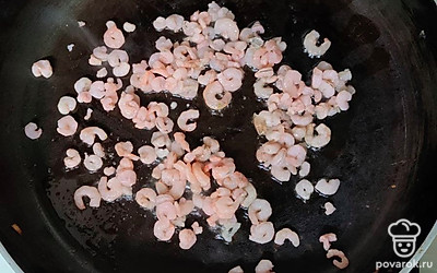 В сковороде обжарьте свиное сало, чтобы вытопилось немного жира, а затем уберите выжарки. Они больше не потребуются. На сковороду с жиром бросьте креветки и обжаривайте их 2-3 минуты.