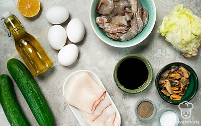 Мидии залейте кипятком на пару минут, затем слейте воду и разрежьте на половинки. Креветки разморозьте. Кальмаров помойте и очистите. Листья салата помойте, обсушите и крупно порежьте. Огурцы помойте и нарежьте кубиками. Помойте лимон, разрежьте его пополам и выдавите из половины сок.