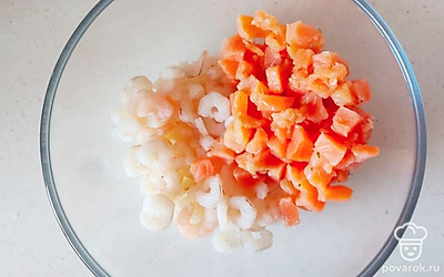 Семгу нарежьте произвольными небольшими кусочками. Отправьте в отдельную миску. Добавьте размороженные креветки.