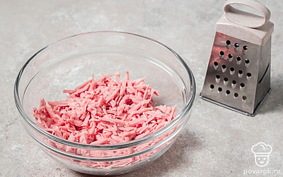 Натрите сосиски на мелкой или средней терке.