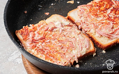 Когда масло нагреется, выложите в него бутерброды начинкой вниз. Обжаривайте тосты с двух сторон 2-3 минуты. 