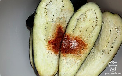 В миску к баклажанам добавьте масло, паприку и соль по вкусу. Тщательно перемешайте.