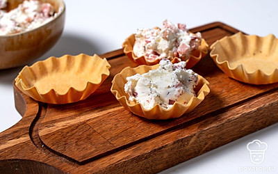 Наполните тарталетки готовой начинкой. Делать это удобнее всего простой ложкой или кондитерским мешком. 