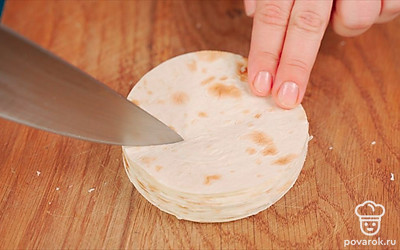 Из листов тонкого лаваша вырежьте круги диаметром 8-9 см. На каждую порцию потребуется 2 кружка, на 16 ракушек — 32 кружка. В каждом кружке сделайте надрез, равный примерно 1/3 диаметра. Соедините края с небольшим нахлестом и скрепите их зубочисткой. Уголочек, появившийся внизу во время соединения, аккуратно выправите на другую сторону, с внешней стороны получится небольшая выемка.