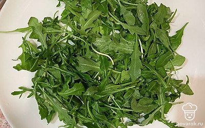 Моем руколу, обсушиваем от лишней влаги и выкладываем на большое блюдо.