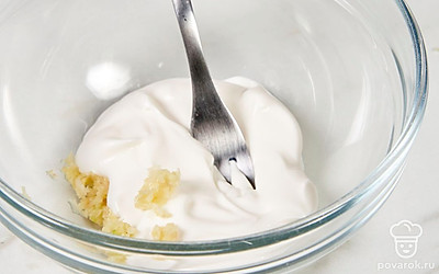 Выложите майонез в чистую миску. Пропустите чеснок через пресс. Перемешайте его с майонезом в миске. 