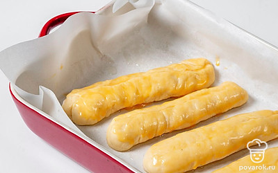 Взбейте куриное яйцо в небольшой миске. Смажьте поверхность каждой заготовки яйцом.