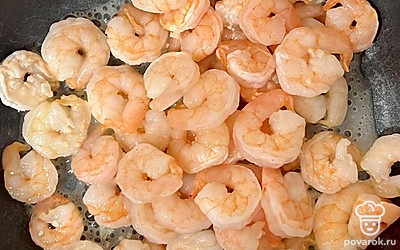 В ложке растительного масла обжариваем измельченный чеснок, а затем добавляем в сковороду креветки. Жарим 3 минуты, чтобы они не стали резиновыми.