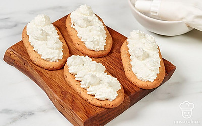 Наполните кондитерский мешок творожной массой. Выложите начинку на печенье. 