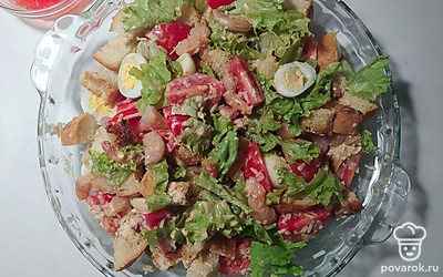 Затем соберите салат. В плоскую тарелку выложите помидоры, яйца порезанные на две части, листья салата, креветки и заправьте соусом. Сверху украсьте сухарями и присыпьте натертым сыром.