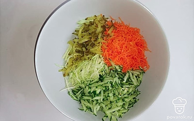 Капусту и огурцы промойте и натрите на терке, затем поместите в большую миску. Морковь измельчите на средней терке.