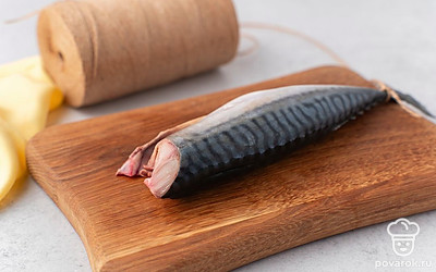 Достаньте рыбу из маринада и высушите бумажными полотенцами. Привяжите к хвосту скумбрии веревку и подвесьте ее сушиться на 2 часа над миской, куда будет стекать маринад.