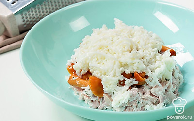 Отделите белки от желтков. Натрите их по отдельности на средней терке. Выложите белки на грибы. Смажьте сметаной.