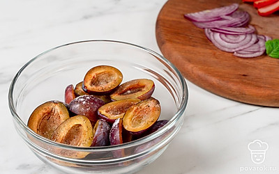 Нарежьте сливы крупными полукруглыми дольками, посыпьте их оставшимися солью и перцем. Нарежьте сырокопченую курицу тонкими ломтиками. Нашинкуйте полукольцами лук. Отделите листочки мяты от стеблей.