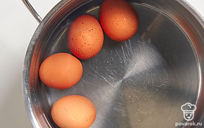 Выложите куриные яйца в сотейник и залейте водой так, чтобы она полностью покрывала их. Доведите воду до кипения, уменьшите огонь и варите яйца на среднем огне 7-8 минут. 