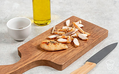 Посолите куриное филе по вкусу и посыпьте сухими специями, обжарьте на сковороде с добавлением 1 ст.л. оливкового масла до золотистой корочки. Дайте остыть и нарежьте ломтиками, положите в салатник.