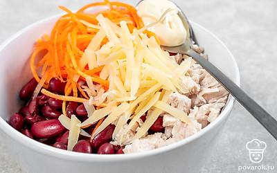 Приготовьте салат. Готовую фасоль переложите в миску. Добавьте к ней филе, морковь по-корейски и тертый сыр. Заправьте ингредиенты майонезом и посыпьте солью по вкусу, а затем тщательно перемешайте.