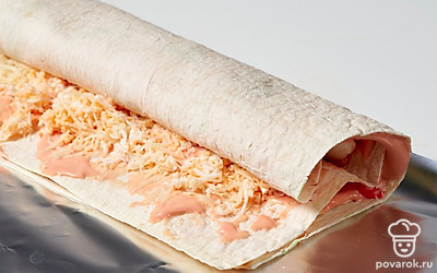 Сверните лаваш в рулет. Плотно запечатайте его в фольгу. Уберите закуску пропитываться в холодильник на 2 часа.