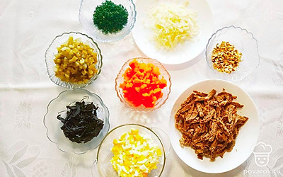 Отварную говядину нарежьте брусочками толщиной около 1 сантиметра. Чернослив нарежьте тонкими полосками. Натрите сыр на крупной терке, а укроп мелко порубите. Яйца нарежьте кубиками, также измельчите и соленые огурцы. Порубите орехи, но не слишком мелко. Нарежьте кубиками отварную морковь.