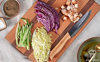 Подготовьте ингредиенты. Нашинкуйте тонкими полосками пекинскую и краснокочанную капусту. Огурец нарежьте соломкой. Куриное филе нарежьте кубиками. В отдельной миске смешайте оливковое масло, соль, перец, уксус и тщательно перемешайте.