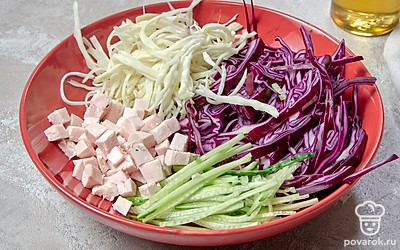 Приготовьте салат. В салатник выложите пекинскую и краснокочанную капусту. Затем добавьте огурец и куриное филе. Заправьте салат оливковым маслом со специями и перемешайте.