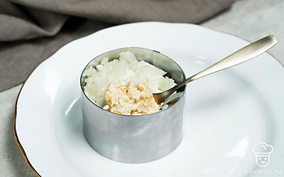 Сформируйте салат. На плоскую тарелку поставьте форму для салатов. Первым слоем выложите половину курино-желтковой массы, затем распределите слой из грибов с белками (половину), а после положите лук. Повторите процедуру с двумя оставшимися половинами слоев. Когда все слои будут распределены, смажьте салат майонезом и обильно посыпьте тертым сыром.